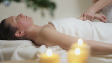 Güzel esmer kadın güzellik salonunun parlak ofisinde el masajı yaptırıyor.