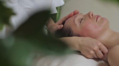 Şakak bölgesinin guaj taşlarıyla masaj yapan tatlı esmer..