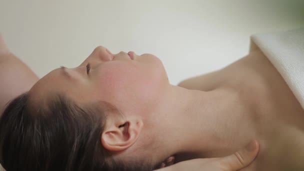 Słodka brunetka na masażu twarzy w salonie spa. Wellness masaż twarzy spa — Wideo stockowe