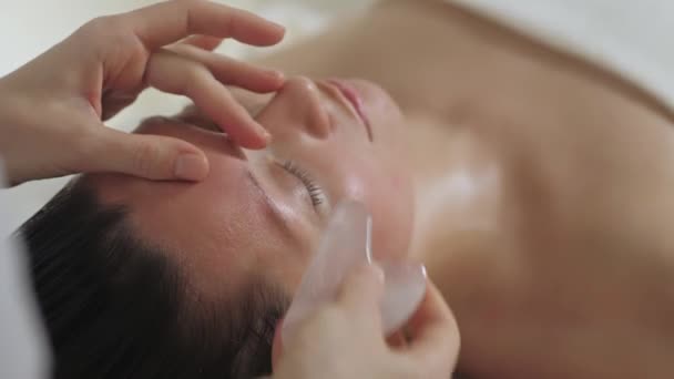 Massagem facial com pedras guache no spa. — Vídeo de Stock
