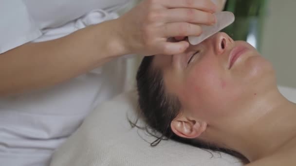 Massagem facial com pedras guache no spa. — Vídeo de Stock