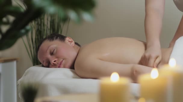 En vacker brunett flicka ligger på en rygg massage förfarande på spa. — Stockvideo