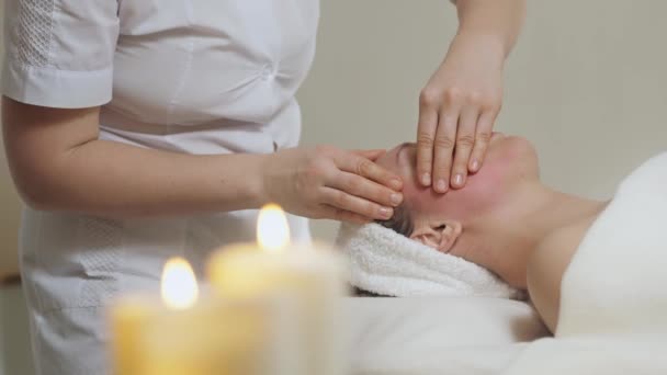 Mulher morena bonito na massagem facial no salão de spa. Wellness spa de massagem facial — Vídeo de Stock