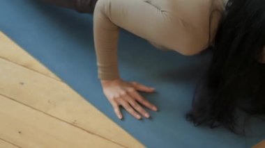 Evde yoga yapan güzel bir genç kadın. asanalar yoga minderinde.