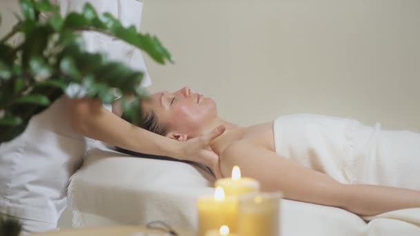 Femme se trouve dans le bureau lumineux du salon de spa et le maître fait un massage — Video