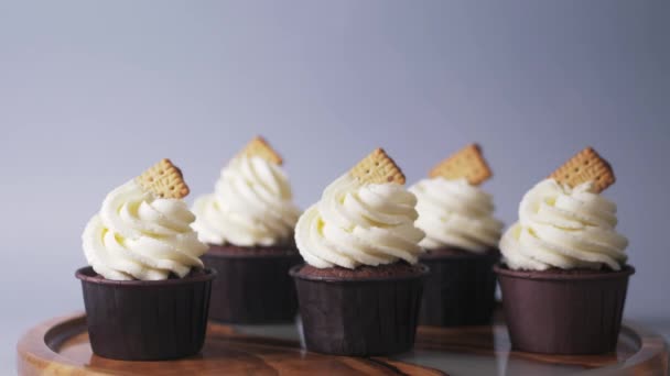 Decoración de cupcakes de chocolate con crema ligera y galletas de arándanos. — Vídeos de Stock