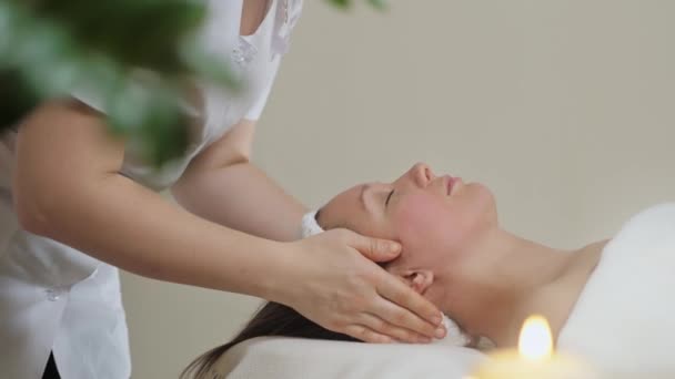 Słodka brunetka na masażu twarzy w salonie spa. Wellness masaż twarzy spa — Wideo stockowe