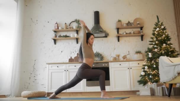 Gezonde yoga vrouw die yoga oefeningen thuis voor Kerstmis doet — Stockvideo