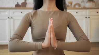 Spor giyimli rahat genç kadın Lotus pozisyonunda meditasyon yapıyor.