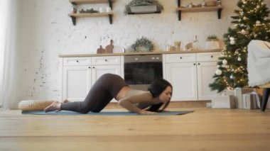 Yoga yapan sağlıklı bir kadın Noel 'den önce evde yoga yapıyor.