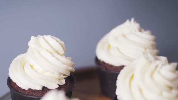 Dekorace hnědé cupcakes s lehkou smetanou cookies. — Stock video