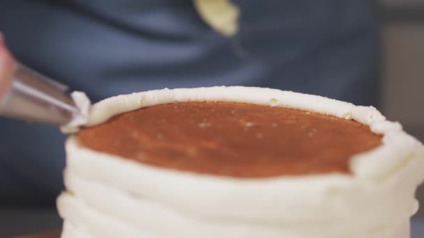 Közelkép a cukrász alkalmazó fehér krém oldalán a torta. — Stock videók