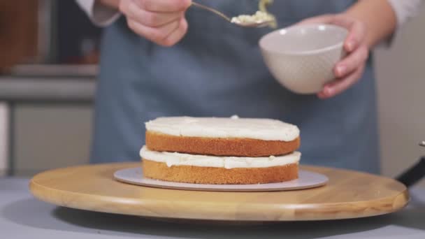 O chef de pastelaria adiciona bolas de chocolate branco ao creme do bolo. — Vídeo de Stock