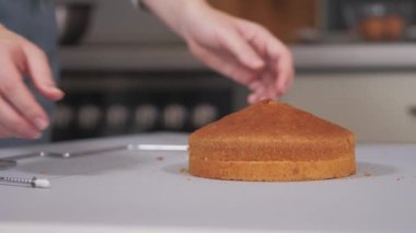 Pasta şefi özel bir kesiciyle pastayı çift katmanlı kesiyor..