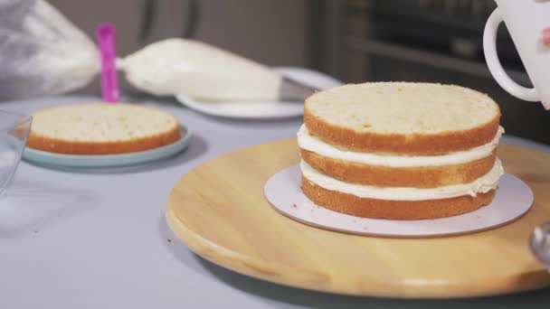 糕点厨师在蛋糕的海绵蛋糕上涂上浸渍剂 — 图库视频影像