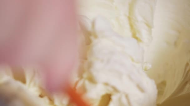 Un chef pâtissier remplit un sac de pâtisserie avec de la crème blanche d'un mélangeur planétaire. — Video