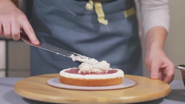 The pastry chef applies the cream to the berry layer between the biscuits. — Stock Video