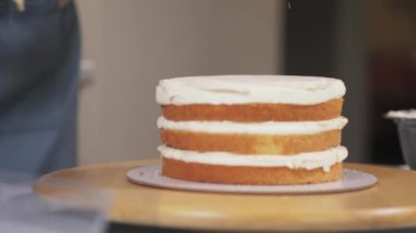 Pasta şefi kekin dördüncü ve son katmanını koyuyor..