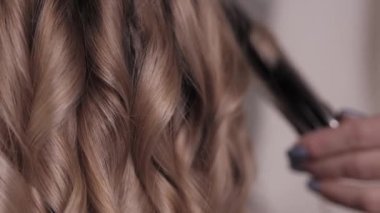 Moda uzmanının yakın çekimi açık renk saçlar sergiliyor. Kuaförde dalgalar.