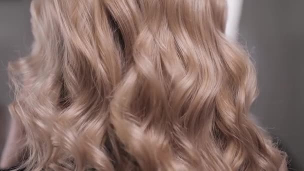 Close-up of a womans hand combing the waves on the blondes head. — Stok Video