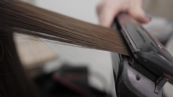 The process of straightening hair in the salon with the help of a steampod. — Stock Video
