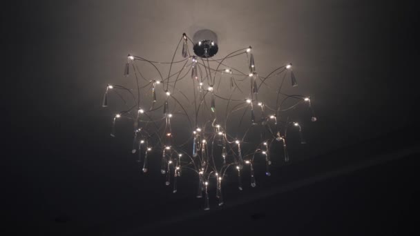Bellissimo lampadario elegante con diodi e cristalli sul soffitto scuro — Video Stock