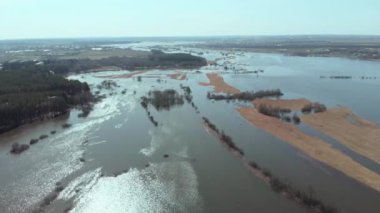 Kamera baharda taşan nehrin üzerinde ileri doğru uçar. Sel