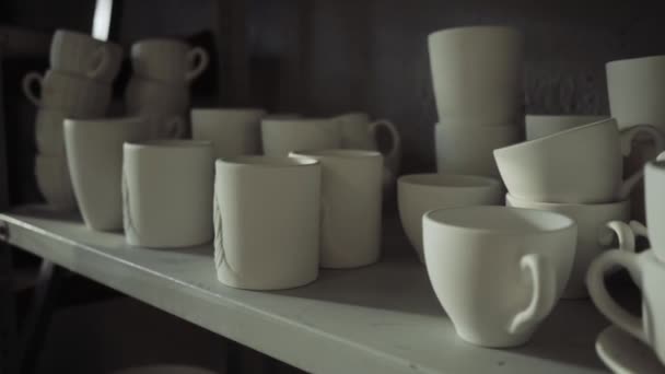 Białe kubki ceramiczne są na półkach w zakładzie produkcyjnym. — Wideo stockowe