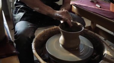Bir çömlekçinin çömlekçinin çömlekçi çarkındaki ürünü bitirdiği yakın plan..