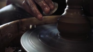 Çömlekçilerin elleri ürünün duvarını düzleştiriyor.