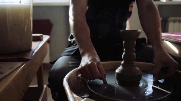 Krukmakaren skär den färdiga produkten av vasen från keramikhjulet. — Stockvideo