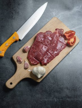 Doğrama tahtasındaki çiğ biftek parçaları.