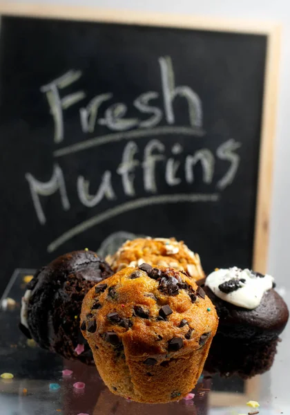 Různorodost čerstvých muffinů se znakovou tabulí — Stock fotografie