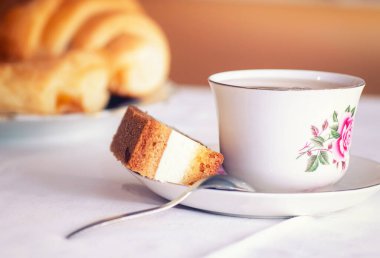 Klasik bir çay fincanında kekle servis edilen bir fincan çay.