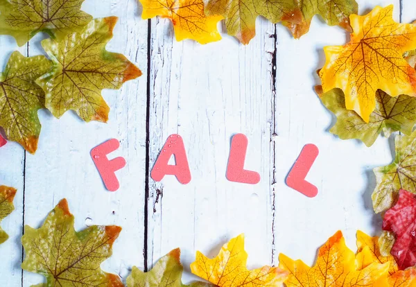 Autumn background with leaves and letters spelling out fall — Stock Photo, Image