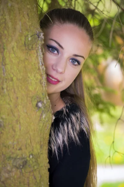 Linda chica escondida detrás del árbol —  Fotos de Stock