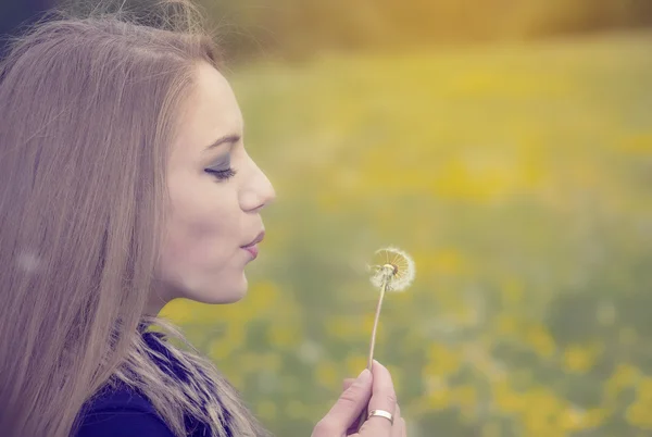 Pretty girl blowing a dandelion — Stock Photo, Image