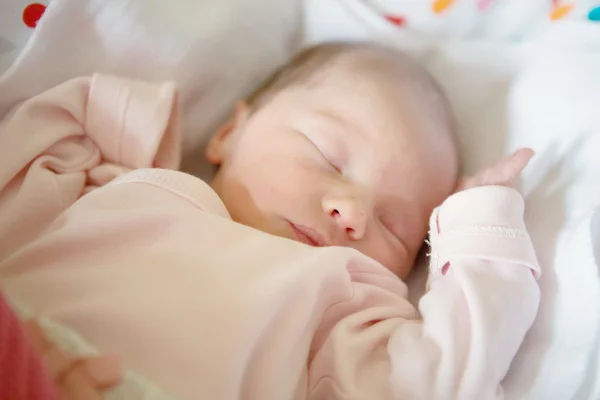 Bébé fille nouveau-née dormant dans son berceau, éclairée par le soleil du matin — Photo