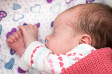 Yeni doğmuş bebek beşikte uyuyor.