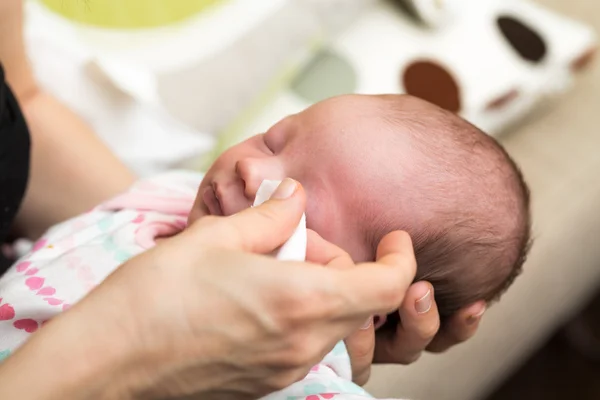 Mãe limpeza olhos de um bebê recém-nascido — Fotografia de Stock