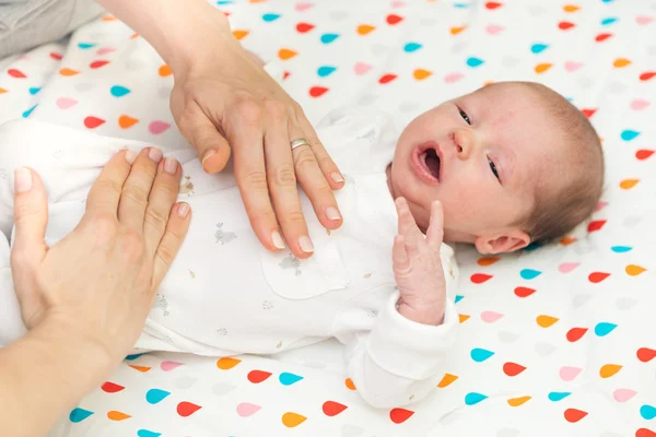 Neugeborenes in weiß auf dem Rücken liegend, mit Koliken — Stockfoto