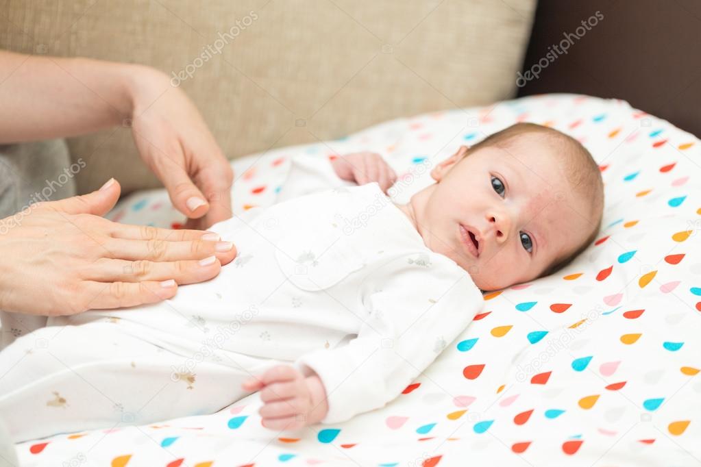 Newborn Baby Dressed In White Laying On Her Back With Colics Stock Photo By C Deymosd