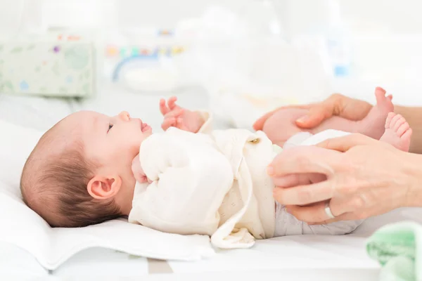 Mãe ajudando sua filha recém-nascida com excercise quadril — Fotografia de Stock