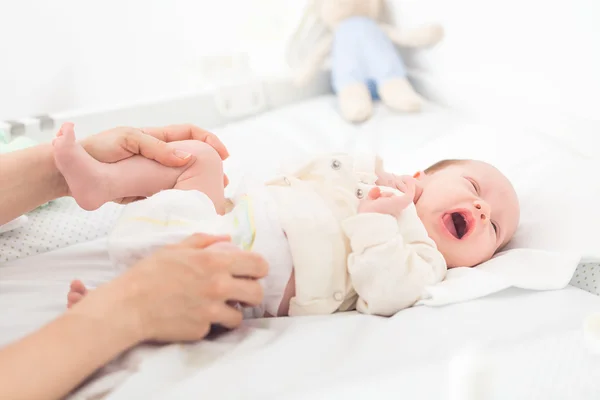 Mãe ajudando sua filha recém-nascida com excercise quadril — Fotografia de Stock