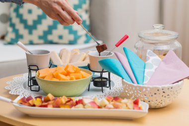 Kavun dilimi bir şiş üzerinde çikolata f harfi ile daldırma el