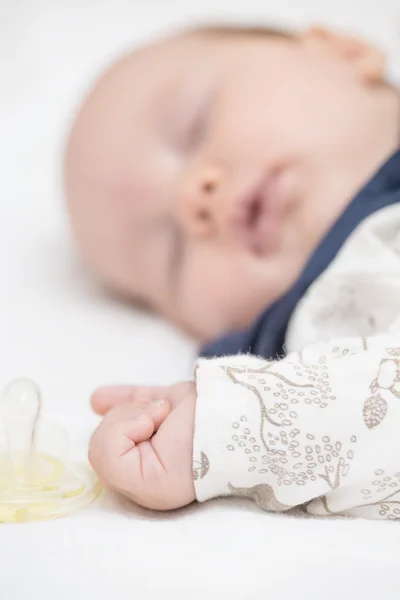 Neugeborenes Mädchen schläft mit ausgestreckter Hand auf dem Bett — Stockfoto