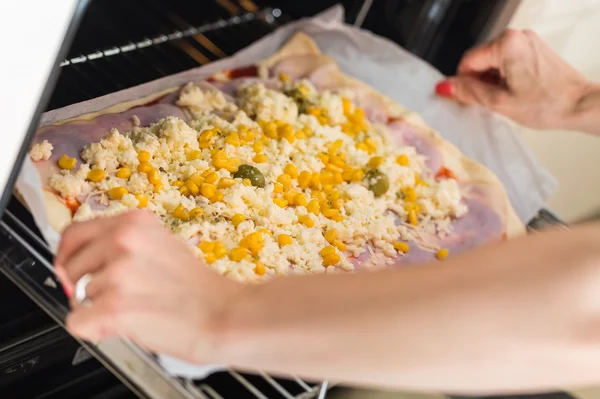 Kadının ellerini koyarak zeytin, jambon, c ile ev yapımı pizza hazır — Stok fotoğraf