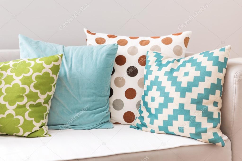 Blue, green and pillow with brown and black circles on the sofa 