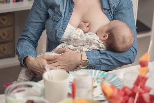 Mother breastfeeding her newborn baby girl during the lunch - br — Stock Photo, Image