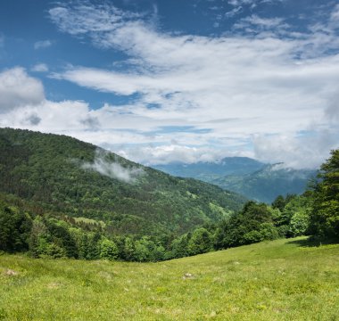Yeşil dağlar ve mavi gökyüzü bulutlu